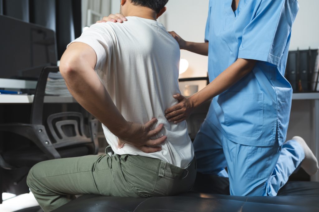 A chiropractor doing an assessment on a patient for a lower back treatment.