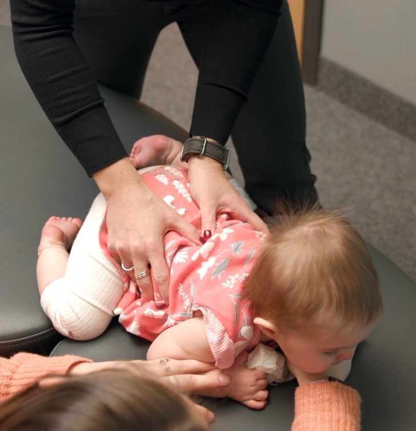 Dr. Christie performing chiropractic adjustment on a baby.